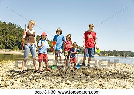 Group of children digging at beach View Large Photo Image Stock Image - Group of children digging at beach. Fotosearch
