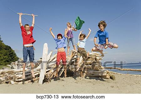 Group of children jumping at beach View Large Photo Image Stock Image - Group of children jumping at beach. Fotosearch