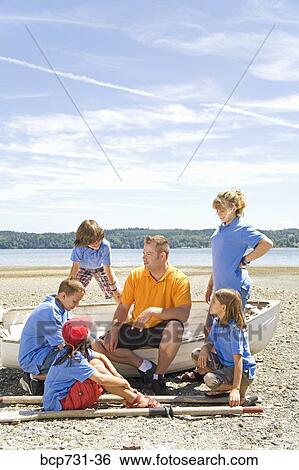 Stock Photograph - Male camp counselor and children at beach. Fotosearch