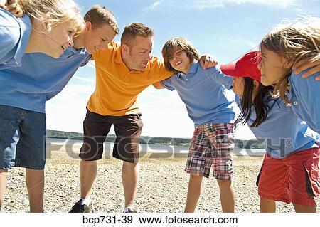 Male camp counselor and children in huddle View Large Photo Image Stock Photo - Male camp counselor and children in huddle. Fotosearch
