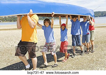 Male camp counselor and children carrying canoe View Large Photo Image Stock Photo - Male camp counselor and children carrying canoe. Fotosearch