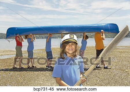 Stock Photography - Male camp counselor and children carrying canoe. Fotosearch