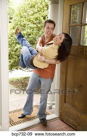 Man carrying wife over threshold of house View Large Photo Image Stock Photo - Man carrying wife over threshold of house. Fotosearch