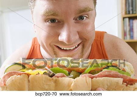 Man holding a big hoagie sandwich View Large Photo Image Stock Image - Man holding a big hoagie sandwich. Fotosearch