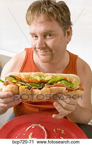 Man holding a big hoagie sandwich View Large Photo Image Stock Image - Man holding a big hoagie sandwich. Fotosearch