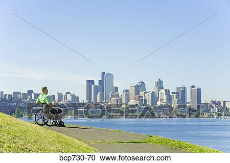 Man in wheelchair looking at city skyline View Large Photo Image Stock Image - Man in wheelchair looking at city skyline. Fotosearch