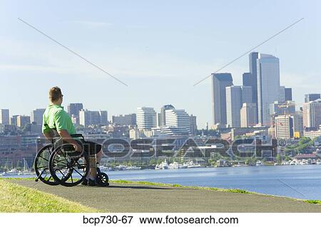 Man in wheelchair looking at city skyline View Large Photo Image Stock Photo - Man in wheelchair looking at city skyline. Fotosearch