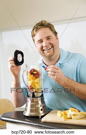 Man making a smoothie View Large Photo Image Stock Image - Man making a smoothie. Fotosearch