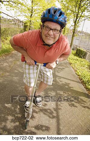 Man riding a scooter View Large Photo Image Stock Image - Man riding a scooter. Fotosearch