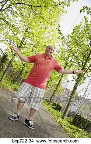 Picture - Man shrugging outside. Fotosearch