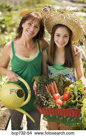 Mother and daughter in vegetable garden View Large Photo Image Picture - Mother and daughter in vegetable garden. Fotosearch