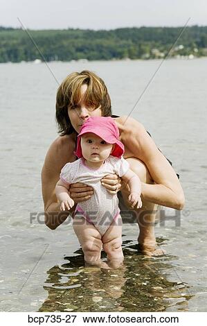Mother holding baby in water View Large Photo Image Stock Photo - Mother holding baby in water. Fotosearch