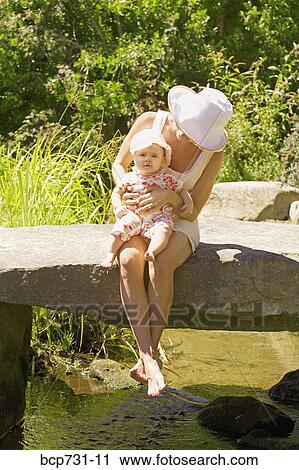 Stock Image - Mother holding baby on lap. Fotosearch