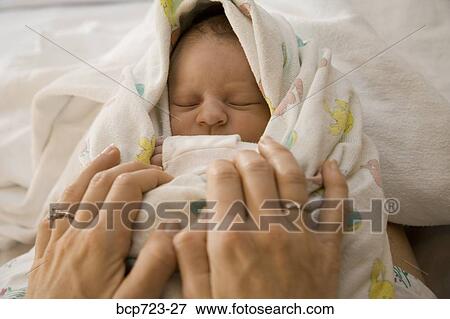 Mother swaddling newborn infant View Large Photo Image Stock Photo - Mother swaddling newborn infant. Fotosearch