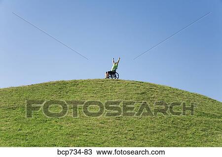 Person in wheelchair on top of hill View Large Photo Image Stock Image - Person in wheelchair on top of hill. Fotosearch
