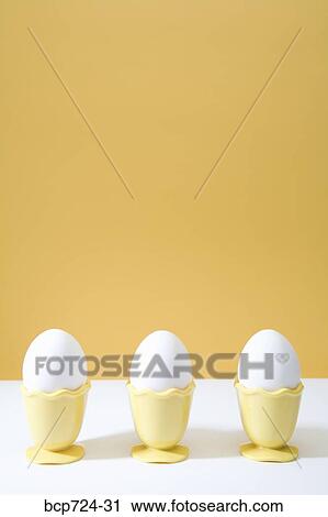 Row of eggs in egg cups View Large Photo Image Stock Image - Row of eggs in egg cups. Fotosearch