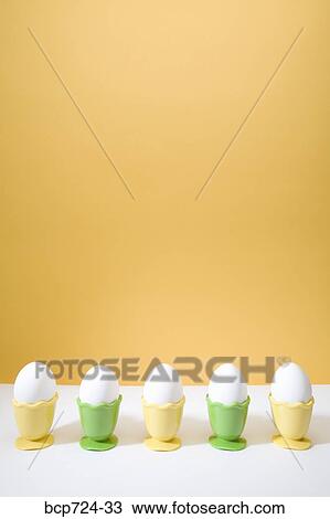Row of eggs in egg cups View Large Photo Image Stock Image - Row of eggs in egg cups. Fotosearch