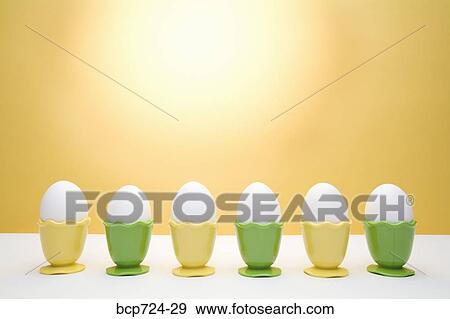 Row of eggs in egg cups View Large Photo Image Stock Photo - Row of eggs in egg cups. Fotosearch