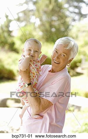 Senior woman holding baby View Large Photo Image Stock Image - Senior woman holding baby. Fotosearch