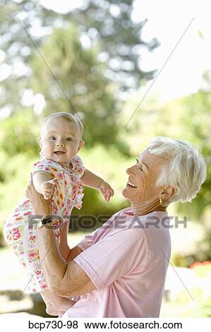 Senior woman holding baby View Large Photo Image Stock Photo - Senior woman holding baby. Fotosearch