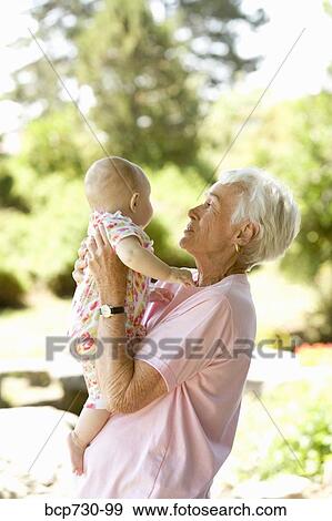 Senior woman holding baby View Large Photo Image Stock Photo - Senior woman holding baby. Fotosearch