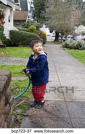 Toddler boy watering plants View Large Photo Image Stock Photo - Toddler boy watering plants. Fotosearch
