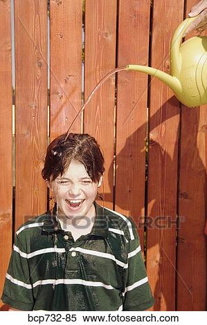 Watering can pouring over boy’s head View Large Photo Image Stock Photography - Watering can pouring over boy’s head. Fotosearch