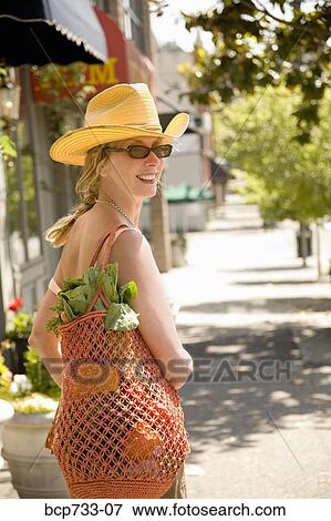 Woman carrying bag with vegetables View Large Photo Image Stock Photo - Woman carrying bag with vegetables. Fotosearch