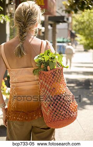 Woman carrying bag with vegetables View Large Photo Image Stock Photography - Woman carrying bag with vegetables. Fotosearch