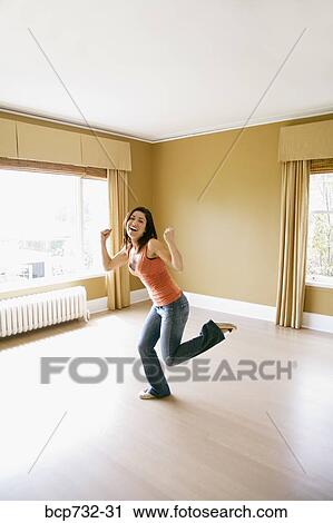 Stock Image - Woman dancing in new house. Fotosearch