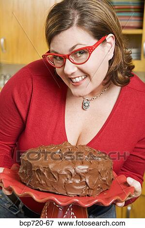 Woman holding frosted cake View Large Photo Image Stock Photo - Woman holding frosted cake. Fotosearch