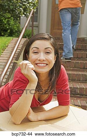 Woman holding key in front of new house View Large Photo Image Picture - Woman holding key in front of new house. Fotosearch
