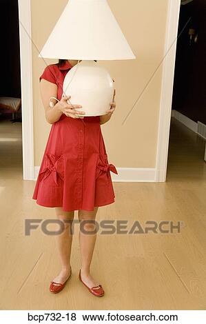 Woman holding lamp in new house View Large Photo Image Stock Photo - Woman holding lamp in new house. Fotosearch