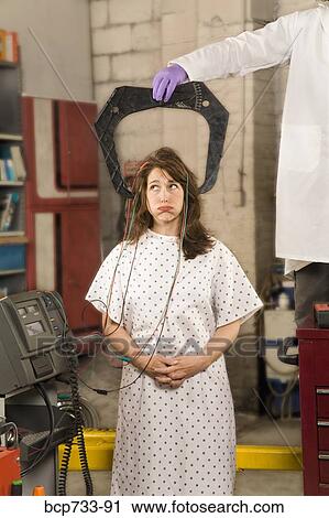 Woman in hospital gown being examined in mechanic shop View Large Photo Image Stock Image - Woman in hospital gown being examined in mechanic shop. Fotosearch
