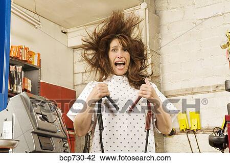 Woman in hospital gown holding jumper cables View Large Photo Image Stock Image - Woman in hospital gown holding jumper cables. Fotosearch