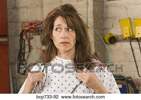 Woman in hospital gown hooked up to wire in mechanic shop View Large Photo Image Stock Image - Woman in hospital gown hooked up to wire in mechanic shop. Fotosearch