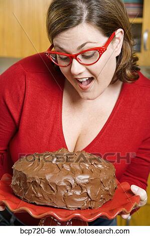 Woman inspecting frosted cake View Large Photo Image Stock Photograph - Woman inspecting frosted cake. Fotosearch