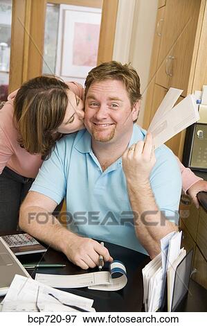 Woman kissing her husband on the cheek View Large Photo Image Stock Photo - Woman kissing her husband on the cheek. Fotosearch