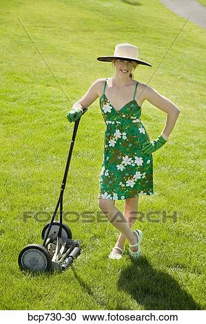 Woman leaning on push lawn mower View Large Photo Image Stock Image - Woman leaning on push lawn mower. Fotosearch