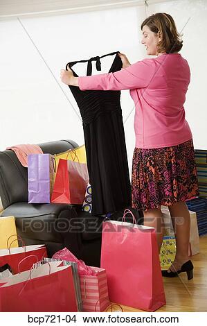 Woman looking at new dress View Large Photo Image Picture - Woman looking at new dress. Fotosearch