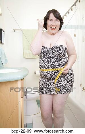 Woman measuring her waist View Large Photo Image Stock Photo - Woman measuring her waist. Fotosearch