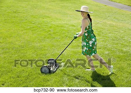 Woman pushing lawn mower View Large Photo Image Stock Image - Woman pushing lawn mower. Fotosearch