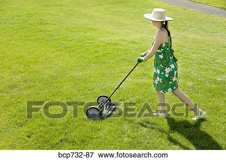 Woman pushing lawn mower View Large Photo Image Stock Photo - Woman pushing lawn mower. Fotosearch