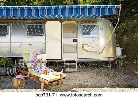 Woman reading in front of motor home View Large Photo Image Stock Image - Woman reading in front of motor home. Fotosearch