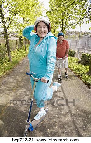 Woman riding a scooter View Large Photo Image Stock Image - Woman riding a scooter. Fotosearch