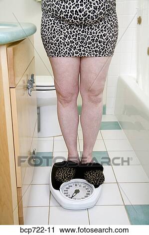 Woman standing on scale View Large Photo Image Stock Image - Woman standing on scale. Fotosearch