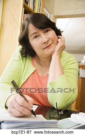 Woman writing a check View Large Photo Image Stock Photo - Woman writing a check. Fotosearch