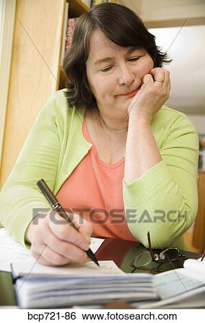 Woman writing a check View Large Photo Image Stock Photograph - Woman writing a check. Fotosearch
