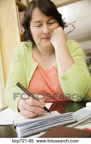 Woman writing a check View Large Photo Image Stock Photography - Woman writing a check. Fotosearch