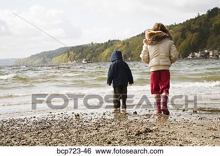 Young boy and girl walking on beach View Large Photo Image Stock Photograph - Young boy and girl walking on beach. Fotosearch